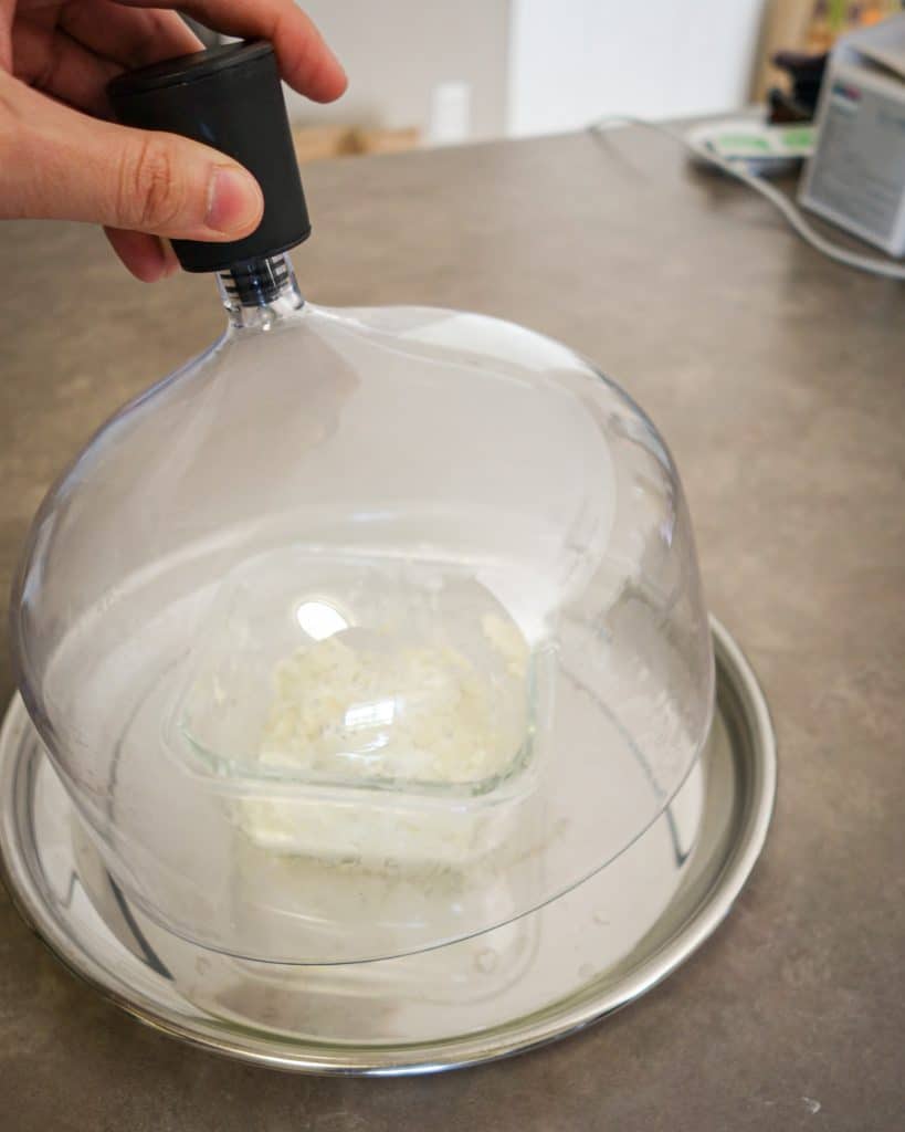Picture of hand putting lid on the opening on the top of a glass dome.