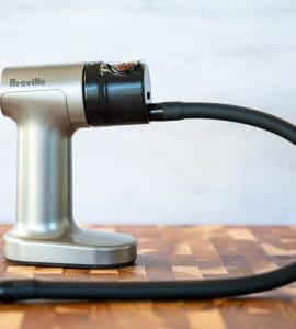 Shot of the Breville Smoking Gun on a cutting board against a white background