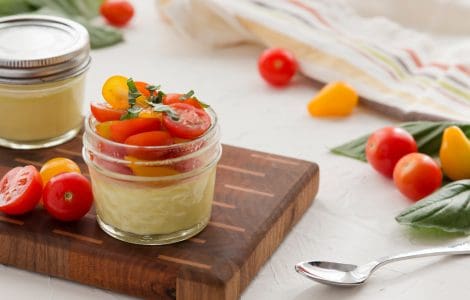 Two Sous Vide Egg Bites in glass jars with tomatoes and fresh basil