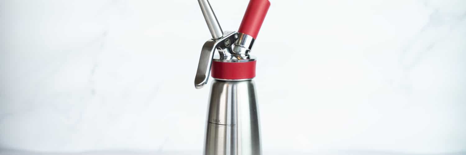 Side view of the Isi Whipped Cream Dispenser against a light background