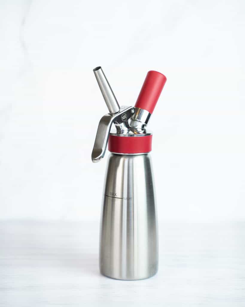 Side view of the Isi Whipped Cream Dispenser against a bright background.
